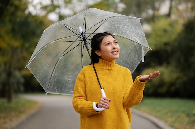 Retrato de chuva de uma mulher jovem e bonita com guarda-chuva