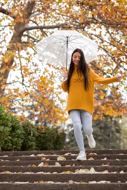 Retrato de chuva de uma mulher jovem e bonita com guarda-chuva