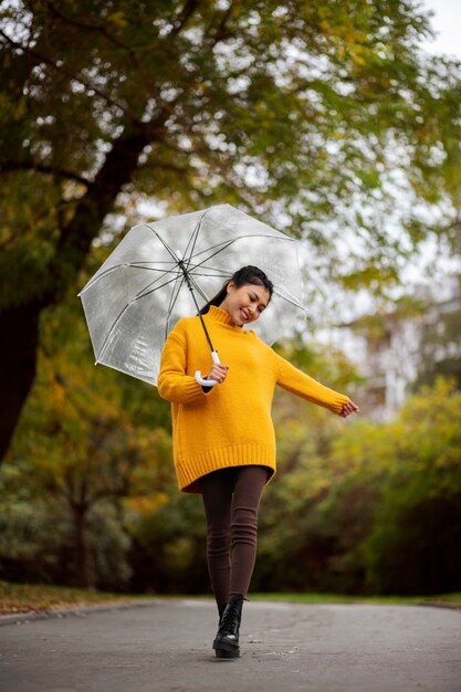Retrato de chuva de uma mulher jovem e bonita com guarda-chuva