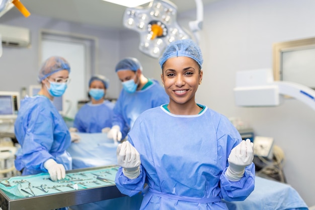 Retrato de cirurgião em pé na sala de cirurgia pronto para trabalhar em um paciente afro-americana trabalhadora médica uniforme cirúrgica no teatro de operação