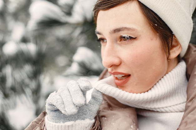 Foto grátis retrato de close-up de mulher com uma jaqueta marrom em um parque nevado