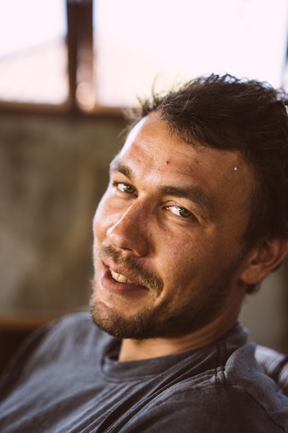 Retrato de close-up de um jovem. O homem ri. Um sorriso malicioso.