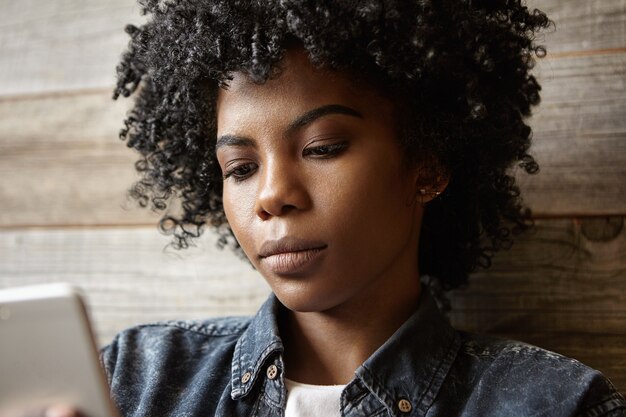 Retrato de close-up de uma atraente garota afro-americana com cabelo encaracolado e pele perfeita e saudável