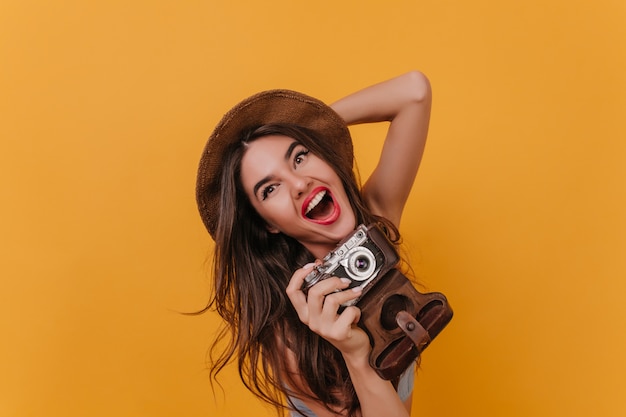 Retrato de close-up de uma fotógrafa encantadora rindo em um espaço colorido