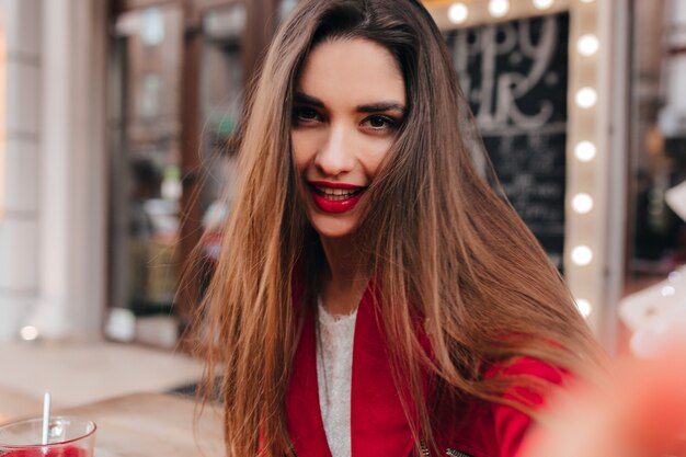 Retrato de close-up de uma jovem magnífica fazendo selfie no espaço desfocado da cidade