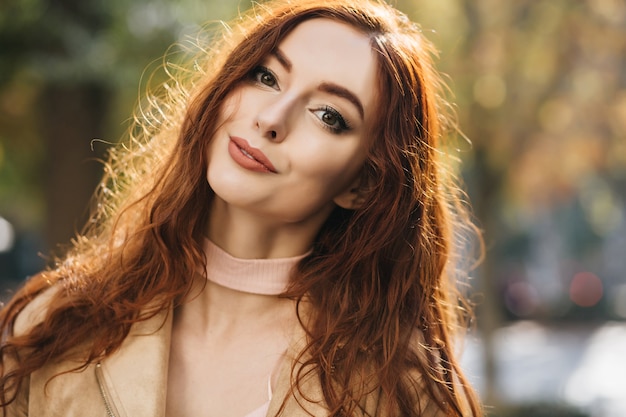 Retrato de close-up de uma mulher ruiva interessada com lindos olhos verdes