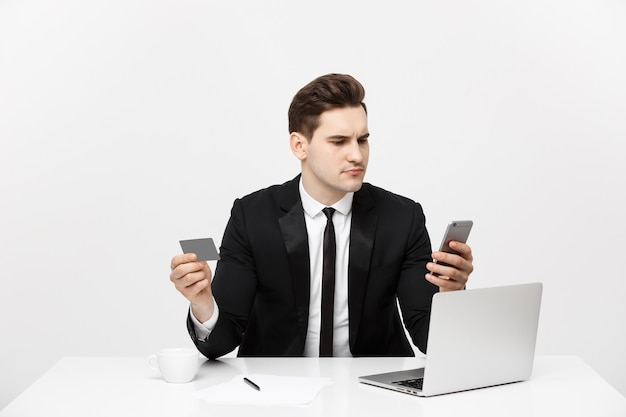 Retrato de conceito de negócio do jovem empresário usando computador laptop e celular, segurando o débito.