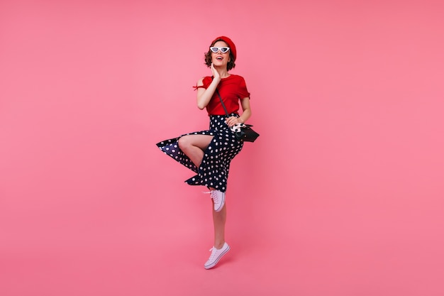 Retrato de corpo inteiro de alegre garota bem vestida se divertindo. afável senhora francesa com cabelos castanhos curtos dançando.