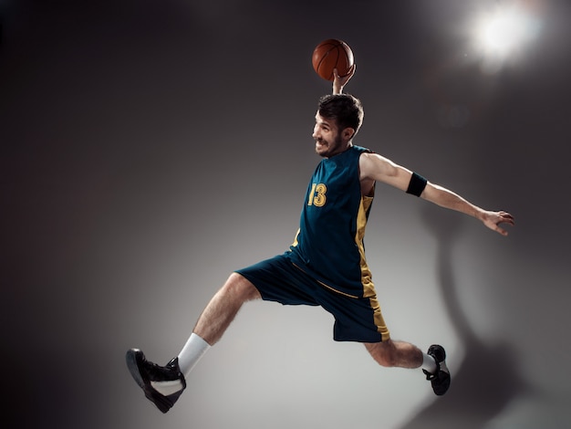 Retrato de corpo inteiro de um jogador de basquete com bola