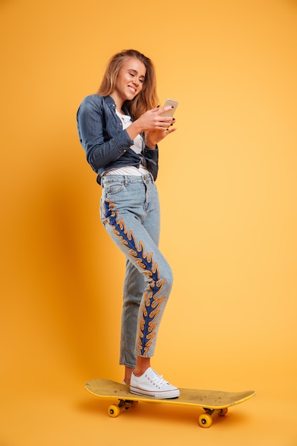 Foto grátis retrato de corpo inteiro de um skatista jovem sorridente