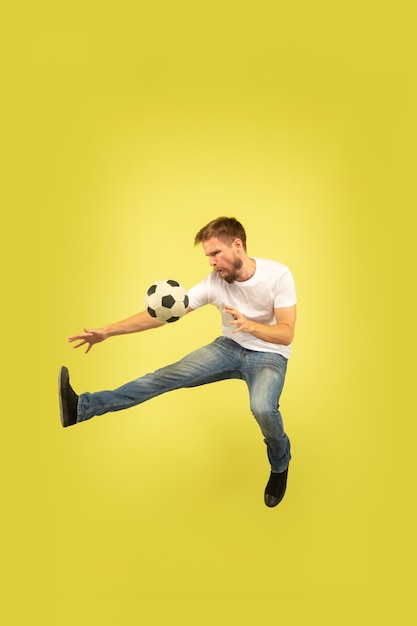 Retrato de corpo inteiro do homem pulando feliz isolado no amarelo