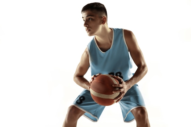 Retrato de corpo inteiro do jovem jogador de basquete com uma bola isolada no fundo branco do estúdio. Adolescente treinando e praticando em ação, movimento. Conceito de esporte, movimento, estilo de vida saudável, anúncio.