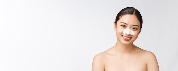 Retrato de cosmetologia de uma bela modelo asiática feminina com máscara no nariz de uma jovem mulher saudável