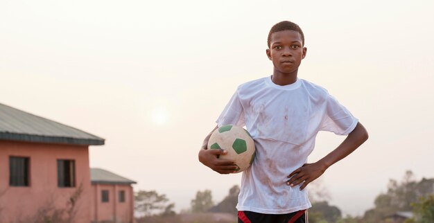 Retrato de criança africana com bola de futebol