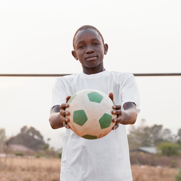 Foto grátis retrato de criança africana com bola de futebol