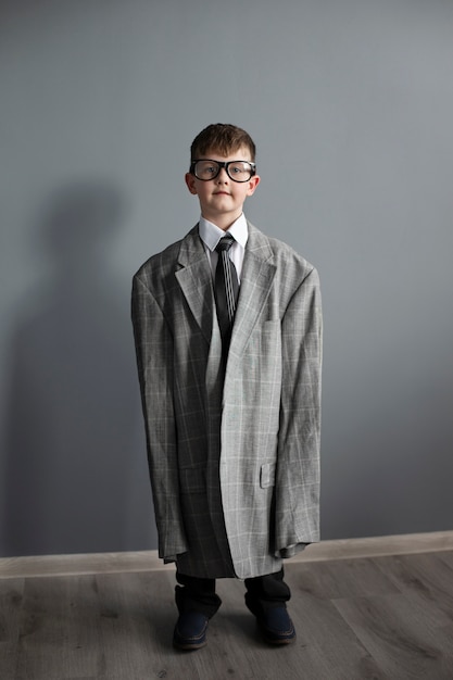 Retrato de criança fofa com terno e óculos de grandes dimensões