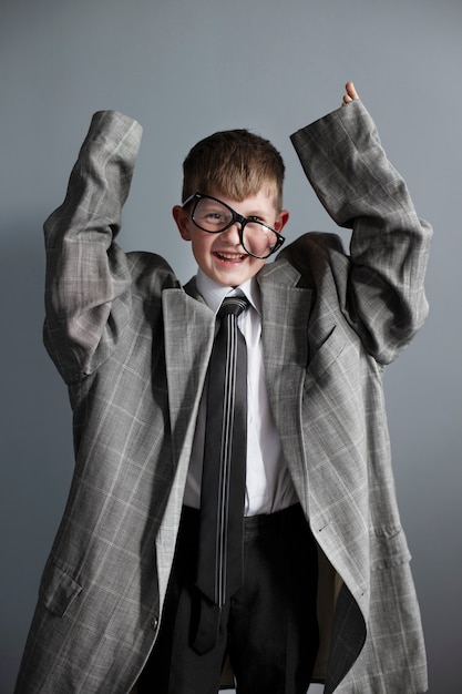 Foto grátis retrato de criança fofa com terno e óculos de grandes dimensões