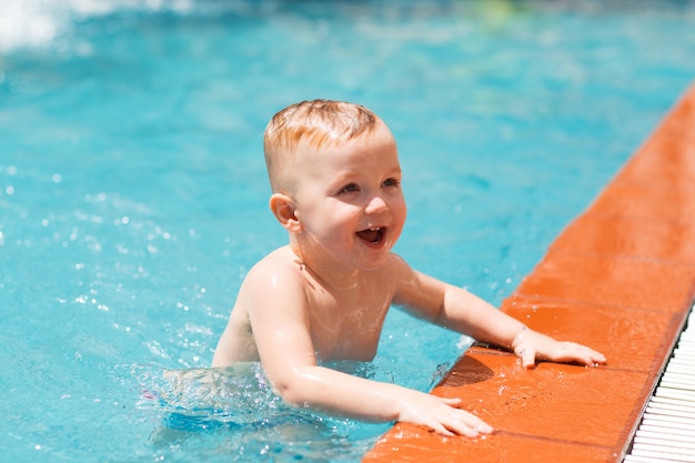 Retrato de criança pequena feliz na piscina