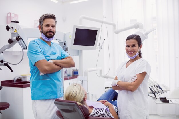 Retrato de dentista masculino e feminino em pé na clínica odontológica