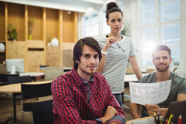 Retrato de designers gráficos sentado em sua mesa