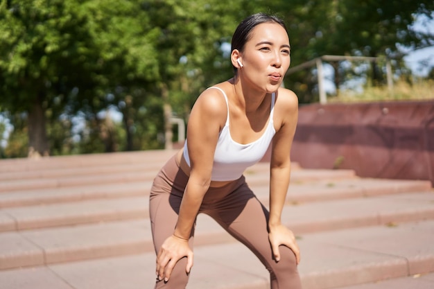 Retrato de desportista ofegante fazendo uma pausa durante o treino de corrida suando enquanto corre ao ar livre