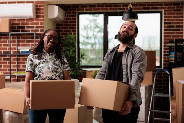 Retrato de diversos homens e mulheres posando com caixas no dia da mudança, desempacotando móveis e coisas para decorar apartamento alugado. Usando o armazenamento de carga para se estabelecer em imóvel comprado por empréstimo.