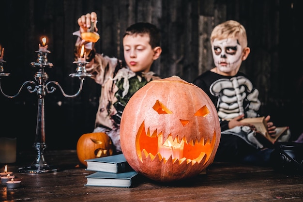 Retrato de dois estudantes legais em trajes assustadores durante a festa de halloween em uma casa velha. conceito de dia das bruxas. Foto gratuita