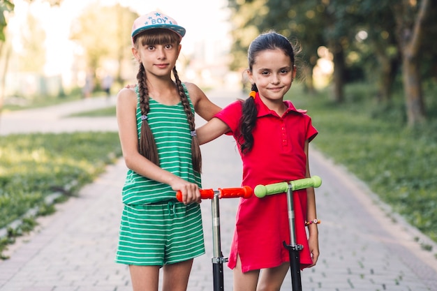 Foto grátis retrato, de, dois, femininas, amigos, com, seu, pontapé scooter