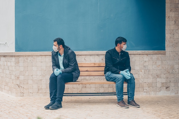 Retrato de dois homens no quintal, sentado em um banco, preocupando-se durante o dia.