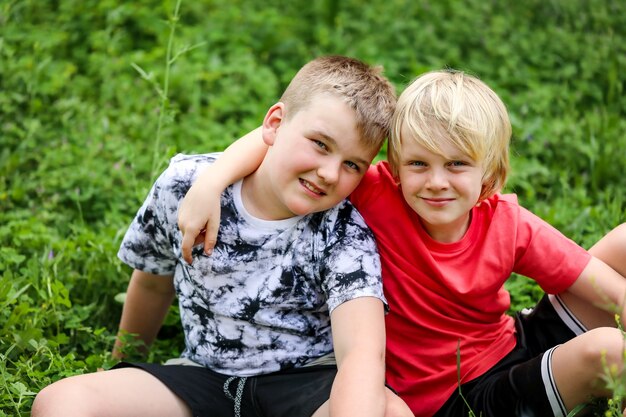 Retrato de dois irmãos loiros sorrindo enquanto se abraçam