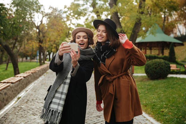 Retrato de duas meninas alegres, vestidas com roupas de outono