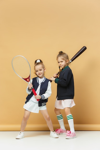 Foto grátis retrato de duas meninas como tenistas segurando a raquete de tênis.