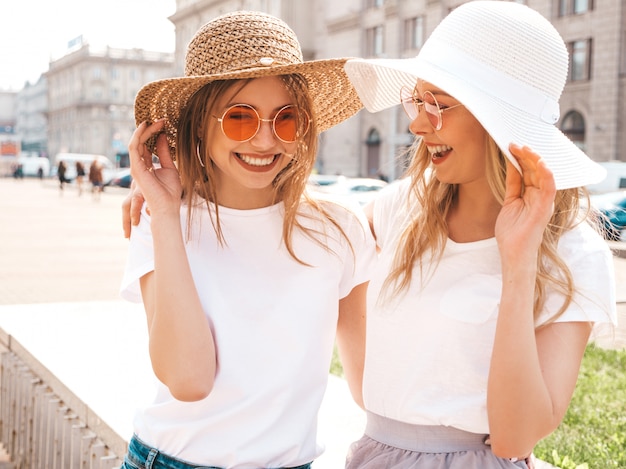 Retrato de duas meninas de hipster loira sorridente jovem bonita em roupas de camiseta branca na moda verão.