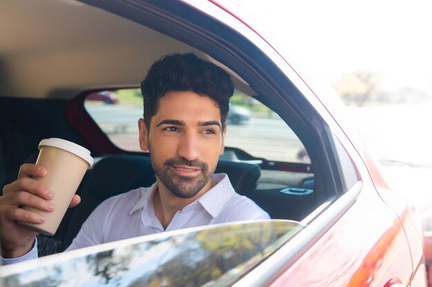 Retrato de empresário tomando café a caminho do trabalho no carro