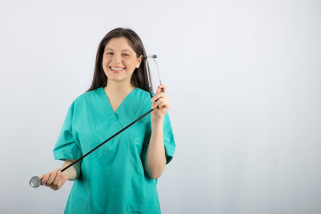 Retrato de enfermeira com estetoscópio posando em branco.