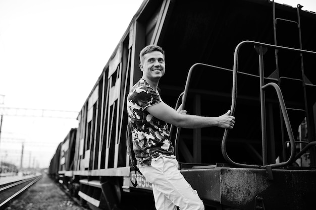 Retrato de estilo de vida de homem bonito posando na estação de trem