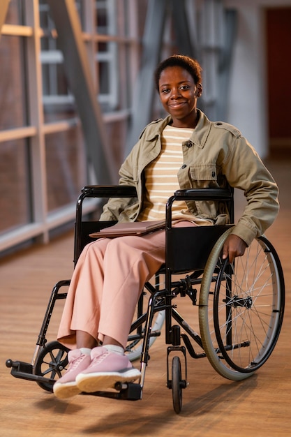 Retrato de estudante sorridente em uma cadeira de rodas