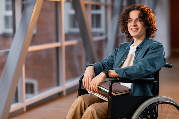 Retrato de estudante sorridente em uma cadeira de rodas