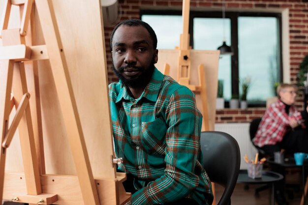 Retrato de estudante sorridente participando da aula de arte desenvolvendo novas habilidades artísticas para o crescimento pessoal aprendendo técnicas gráficas no estúdio de criatividade. Modelo de vaso de desenho de homem pintor. Conceito criativo