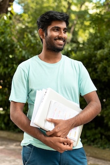 Retrato de estudante universitário segurando alguns livros