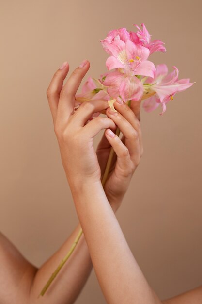 Retrato de estúdio com as mãos segurando flores