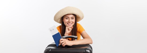 Retrato de estúdio de conceito de viagem de uma jovem bonita segurando passaporte e bagagem isolada em branco