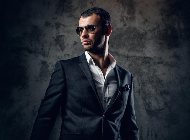 Retrato de estúdio de homem moderno sério na camisa branca e jaqueta de negócios em fundo cinza.