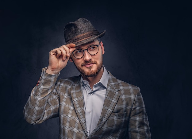 Foto grátis retrato de estúdio de um hipster barbudo de chapéu e óculos usando