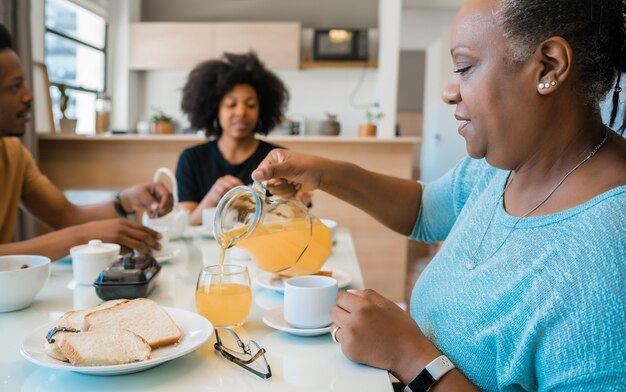 Retrato de família afro-americana, tomando café da manhã juntos em casa. Conceito de família e estilo de vida.