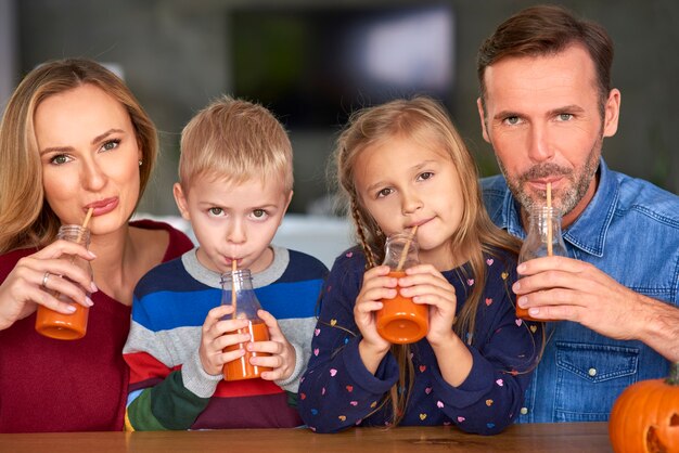 Retrato de família feliz bebendo smoothie