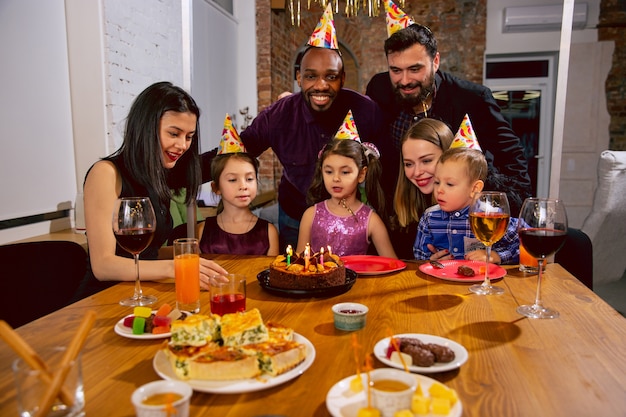 Retrato de família multiétnica feliz comemorando aniversário em casa