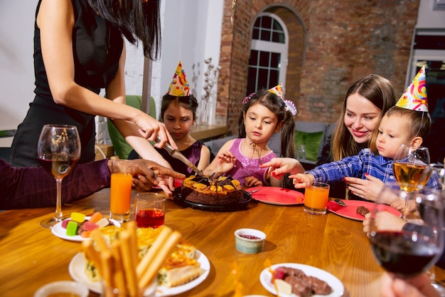 Retrato de família multiétnica feliz comemorando aniversário em casa