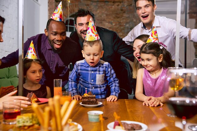 Retrato de família multiétnica feliz comemorando aniversário em casa