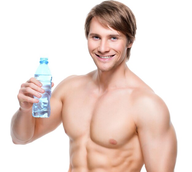 Retrato de feliz esportista musculoso sem camisa segurando água